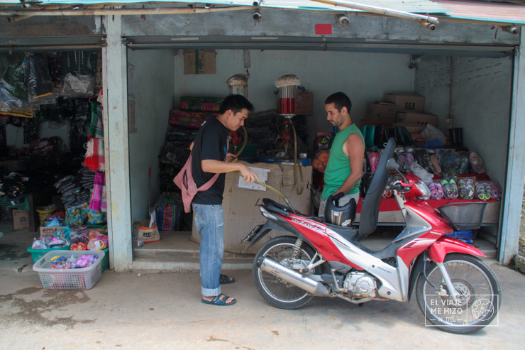 echando gasolina a una moto en Tailandia